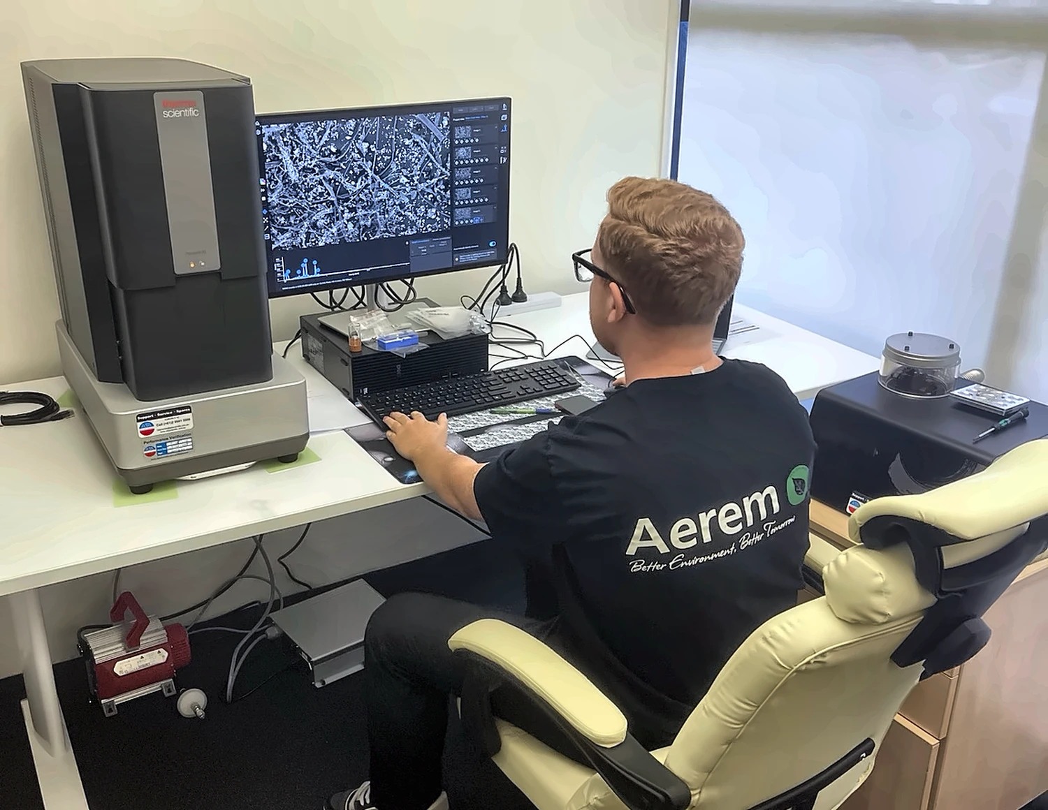 Aerem analyst working at the Phenom XL scanning electron microscope in the Auckland laboratory